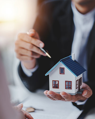 Mann zeigt mit Stift auf Model-Haus